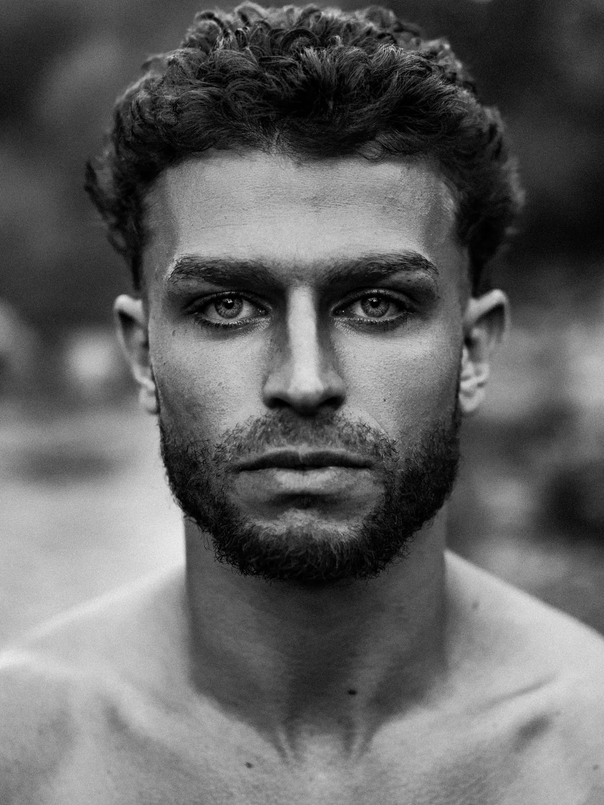Close black and white portrait of Omar Thali, looking directly at the camera
